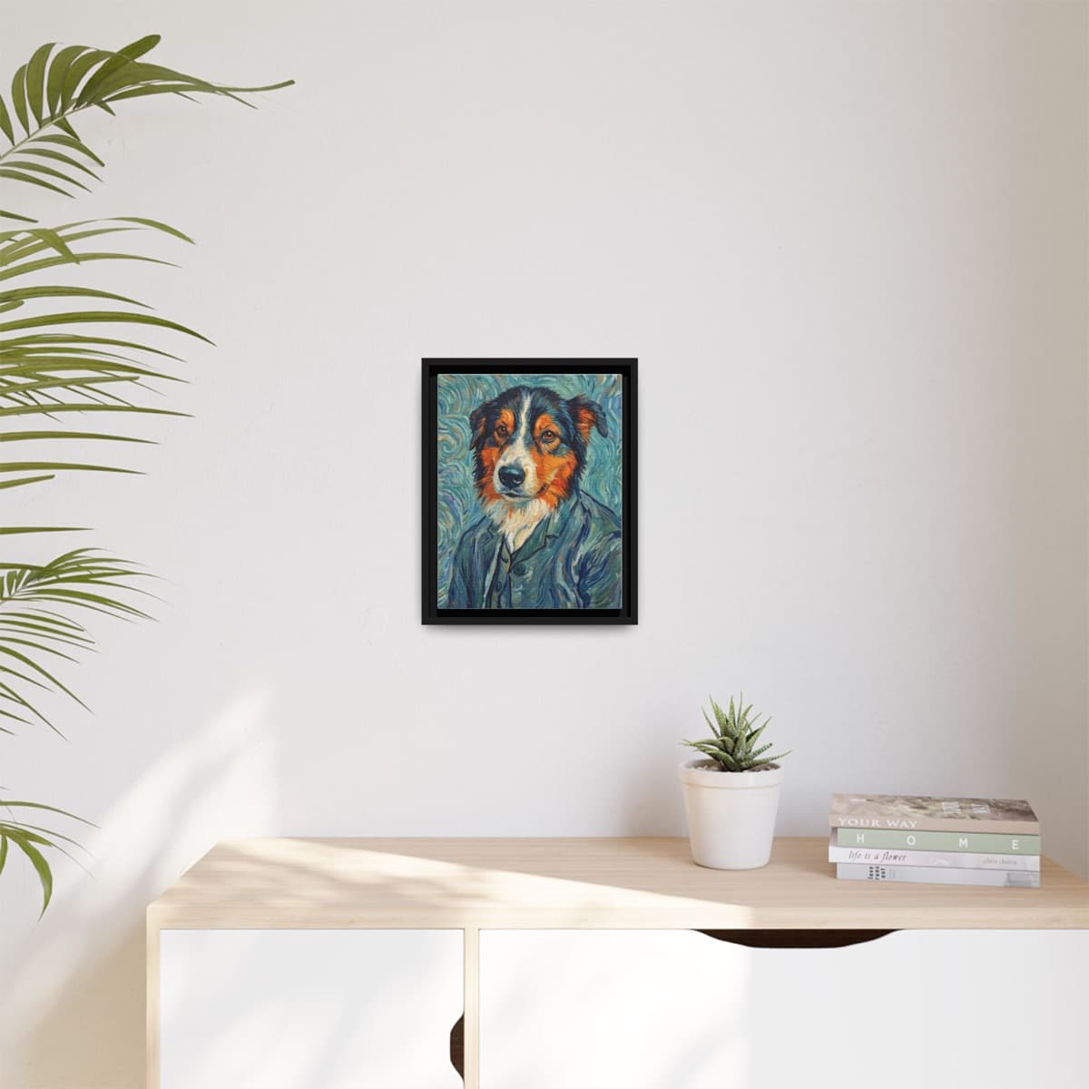 A black-framed print of a Van Gogh-style border collie portrait on a sunlit wall above a wooden console.